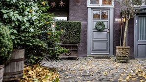 Ein Pflasterhof mit Empfangsbereich, einer dekorativen Laterne und einem Blumentopf.