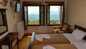 A hotel room with two beds, a desk, a chair, and a TV. - Balkoni Zagoriou (Zagori)