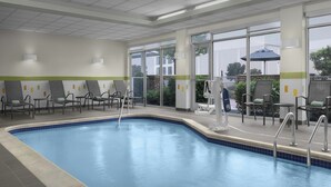An indoor swimming pool with chairs and tables around it, large windows, and a view of the outside. - Fairfield Inn & Suites by Marriott Fayetteville North (Fayetteville)