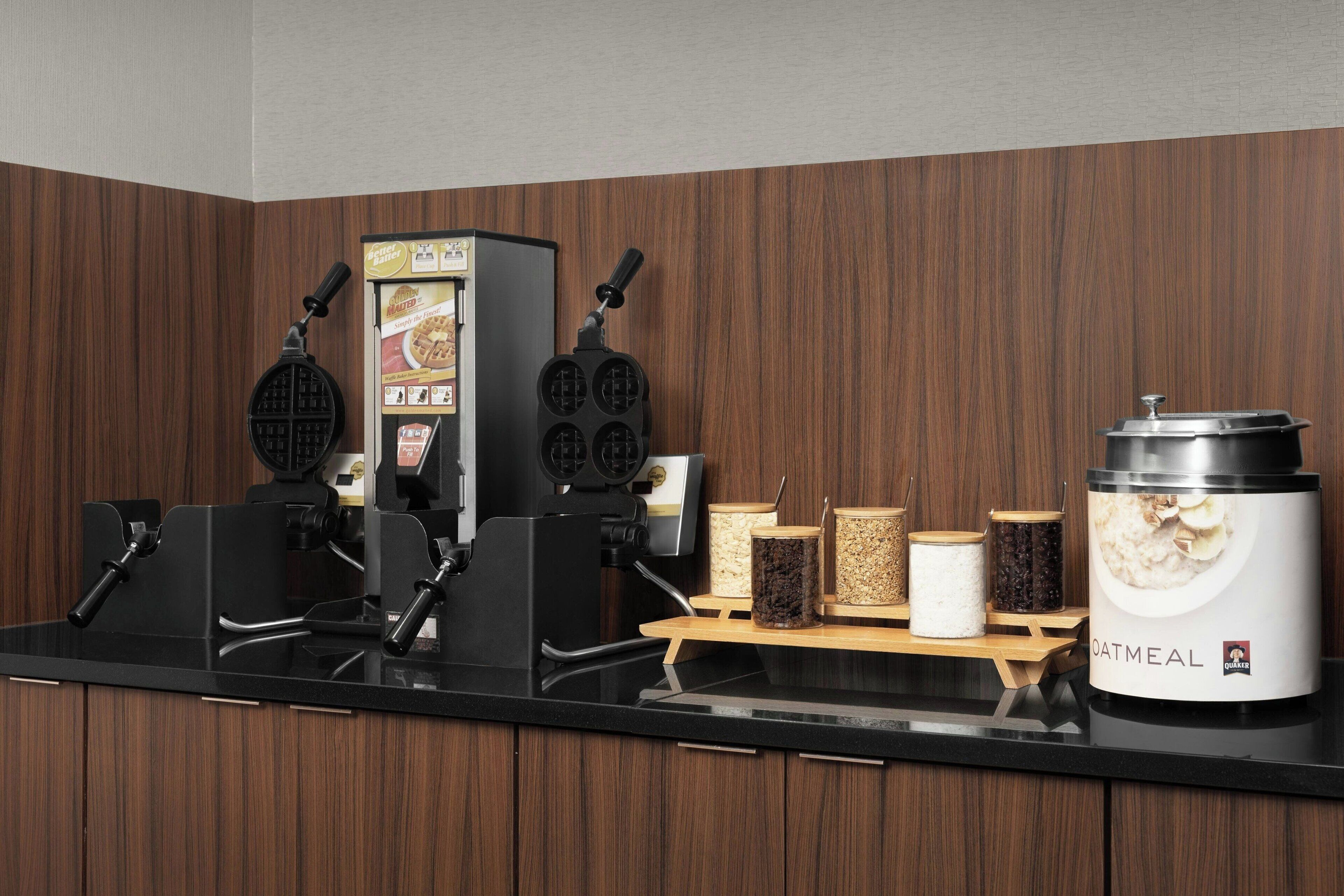 A kitchen with waffle makers, a waffle box, and a container labeled "OATMEAL."