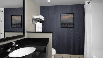 Un bagno moderno con un lavandino nero, un water bianco e una tenda da doccia.