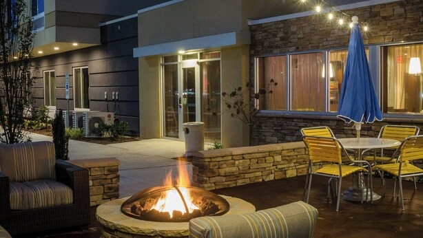 An outdoor patio area with a fire pit, seating, and string lights. - Fairfield Inn & Suites by Marriott Fayetteville North (Fayetteville)