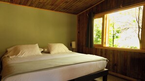 Un lit avec un cadre en bois et un mur vert.
