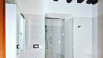 A bathroom with a shower, sink, and toilet.