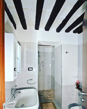 A bathroom with a shower, sink, and toilet.