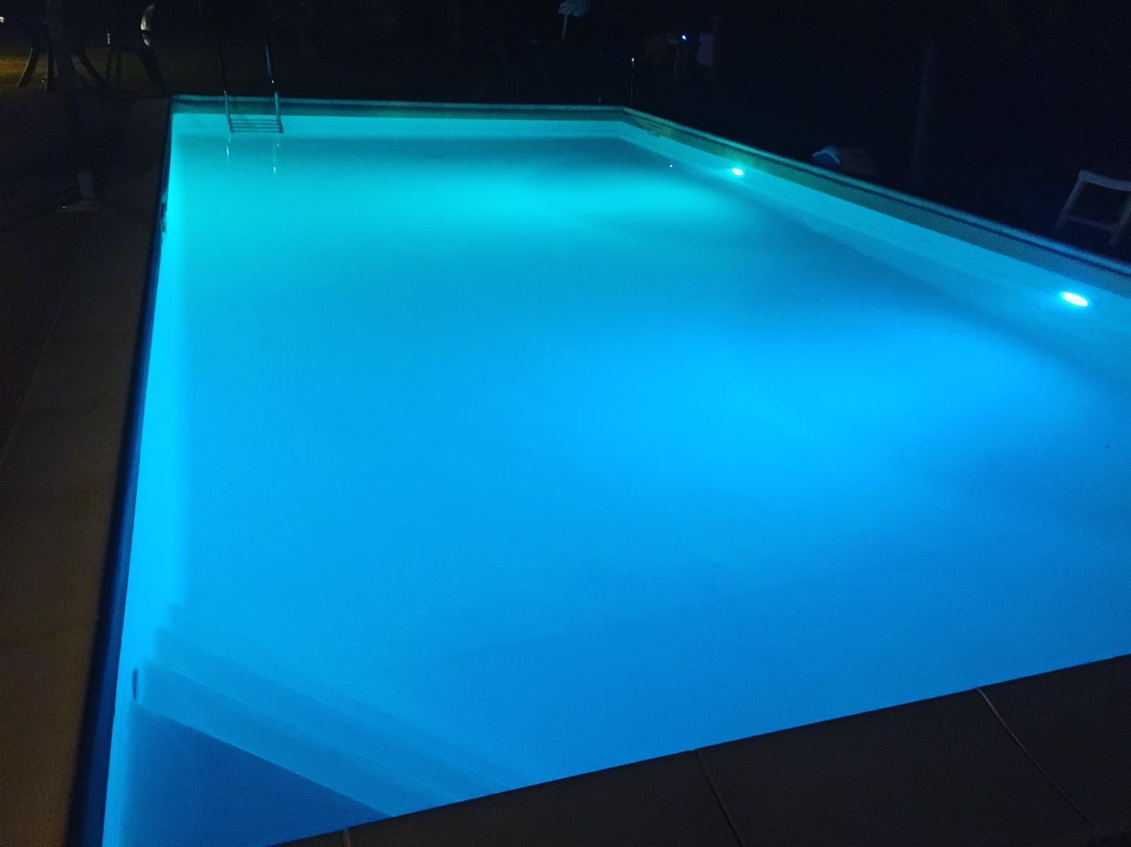 Ein rechteckiger Pool mit blauer Beleuchtung.