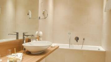 Un baño moderno con un lavamanos grande de color blanco, una bañera y un espejo.