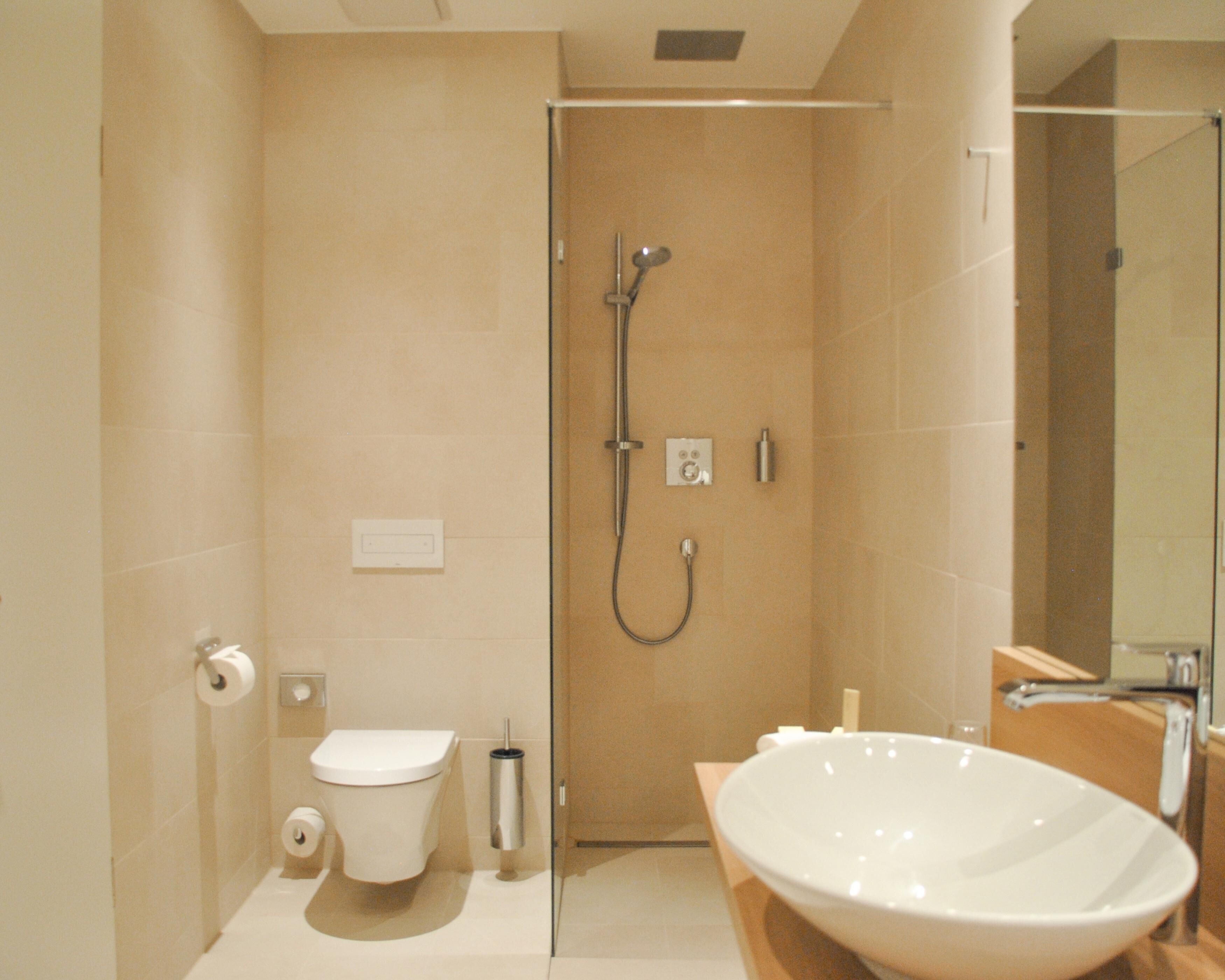 A modern bathroom with a toilet, bidet, and a large sink.