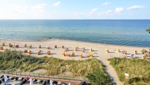 A beach with sand, water, and beach chairs. - SeeHuus Lifestyle Hotel (Timmendorfer Strand)