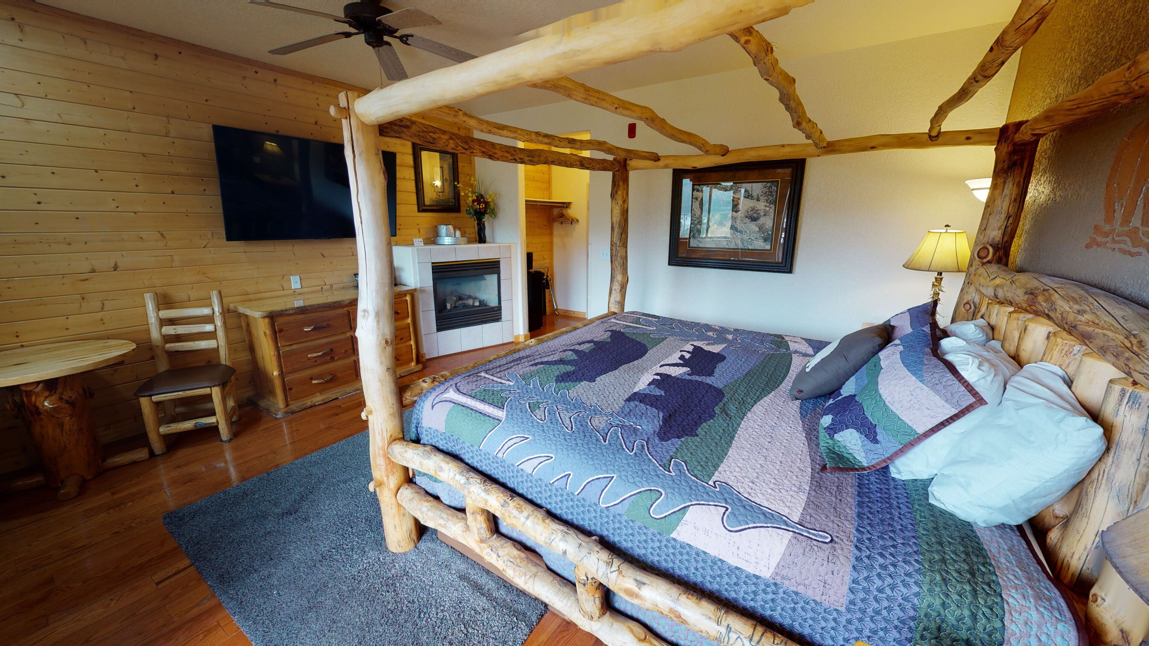 Camera da letto rustica con un letto a baldacchino, mobili in legno e un camino.