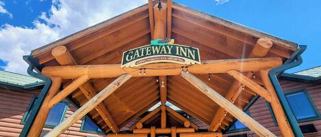 A wooden structure with a sign reading "GATEWAY INN" and a bell.
