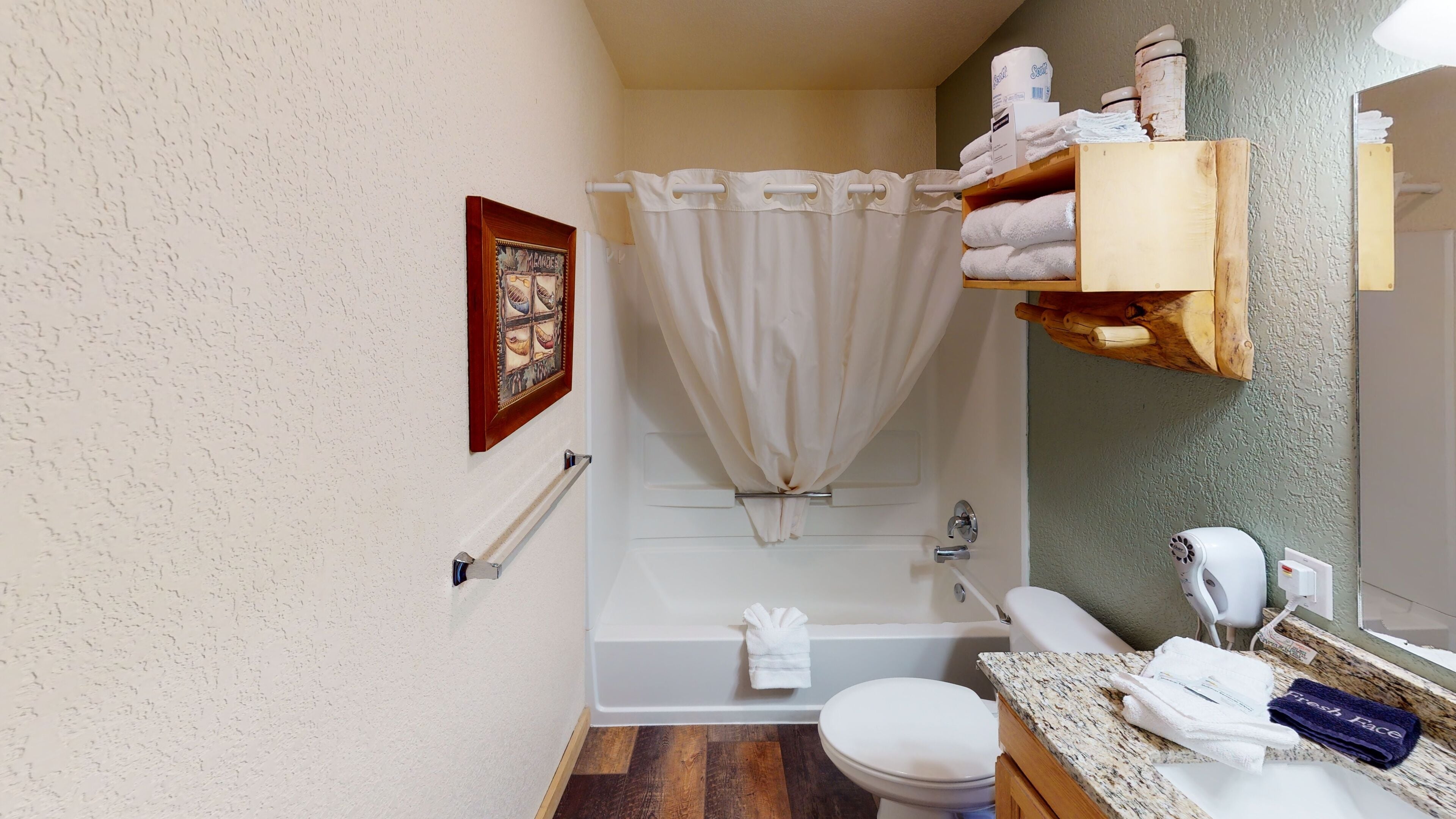 Un baño con bañera, inodoro y tocador con toallas.