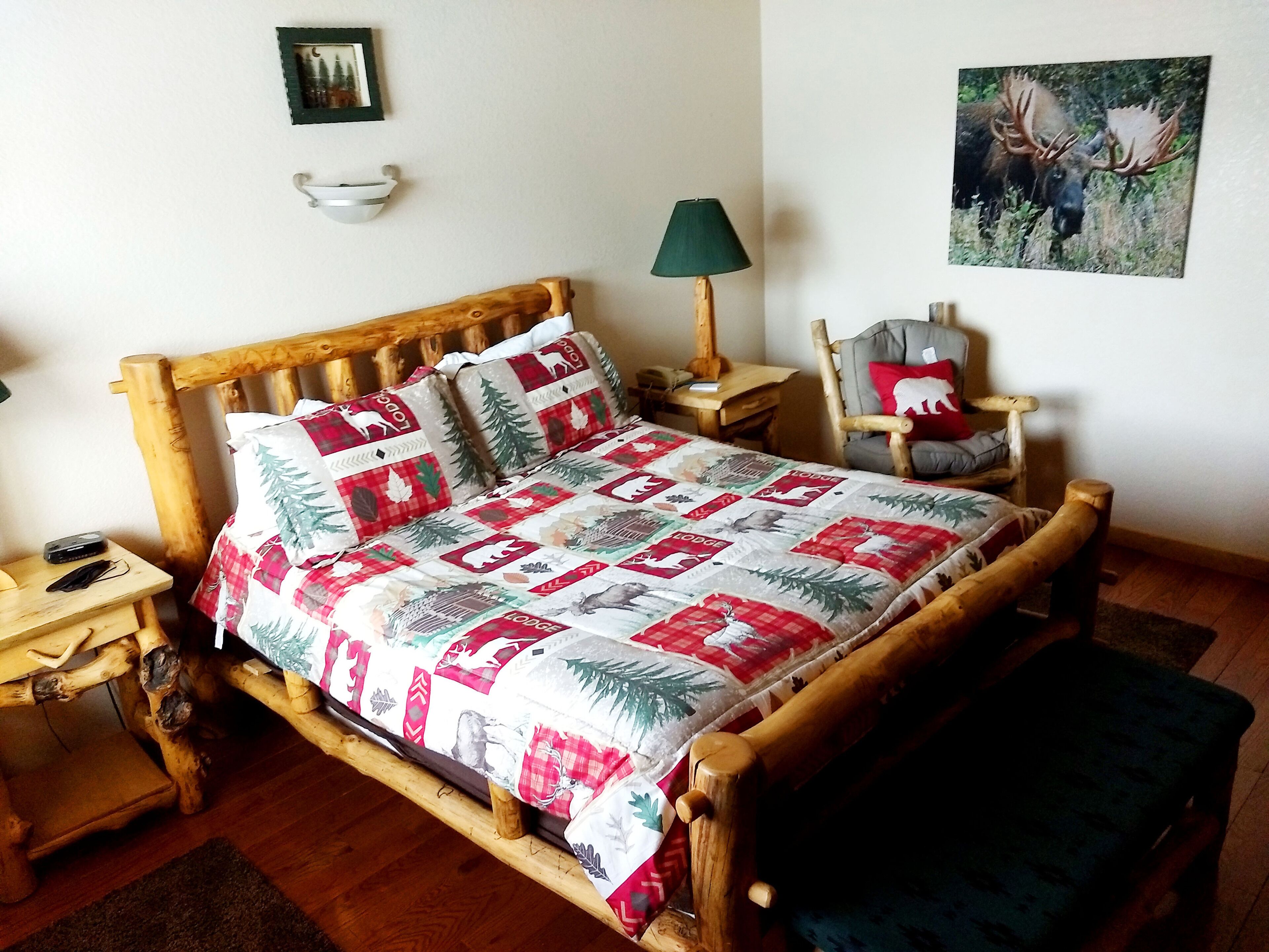 Una habitación acogedora con una cama de madera, una mesita de noche, una silla y una lámpara.