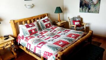 Una habitación acogedora con una cama de madera, una mesita de noche, una silla y una lámpara.