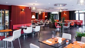 A modern restaurant with red and white decor, multiple dining areas, and large windows. - Le Cottage de Clairefontaine (Chonas-l'Amballan)