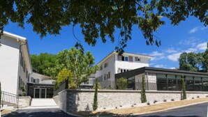 A modern building with a stone facade, large windows, and a flat roof. - Le Cottage de Clairefontaine (Chonas-l'Amballan)