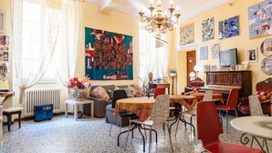 A cozy living room with a sofa, chairs, a coffee table, and a fireplace. - La Gemma di Elena (Lucca)