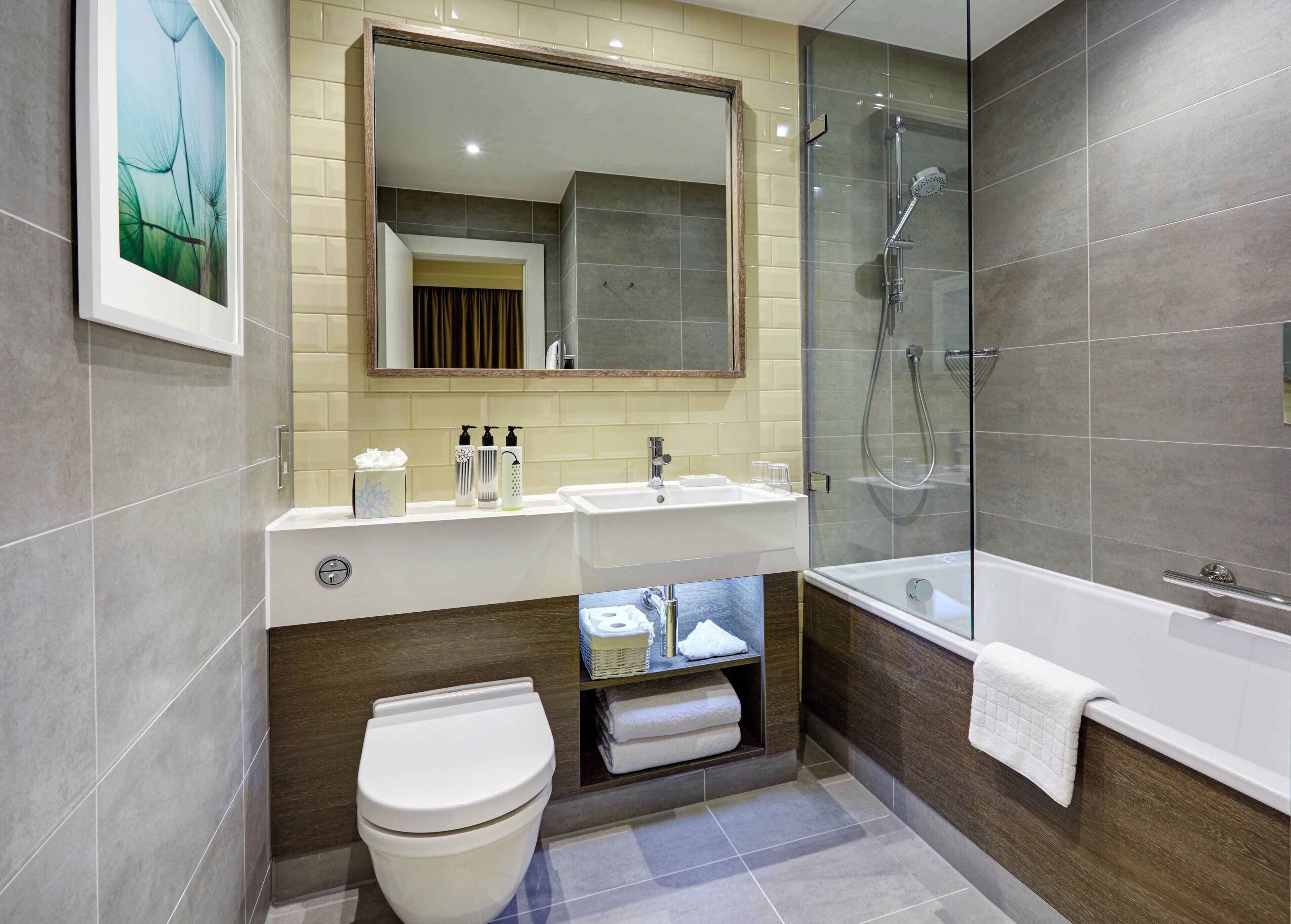 A modern bathroom with a toilet, sink, and bathtub.