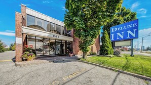 A hotel entrance with a sign reading "Deluxe Inn" and the address "1554". - Deluxe Inn (Toronto)