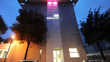 Um edifício de hotel moderno com uma placa chamativa que diz "LAMPARA HOTEL" e uma entrada visível.