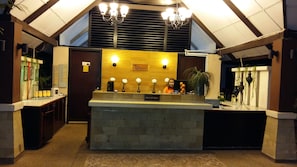 A reception area with a stone counter, a sign reading "RECEPTION", and a chandelier above. - D'Feringghi Haus Hotel & Restaurant (George Town)