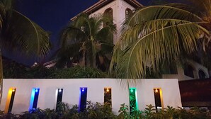 A building with a white facade and arched windows, surrounded by palm trees. - D'Feringghi Haus Hotel & Restaurant (George Town)