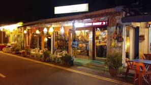 A street-side shop with a signboard, outdoor seating, and various items displayed outside. - D'Feringghi Haus Hotel & Restaurant (George Town)