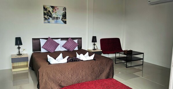 A neatly arranged hotel room with a bed, two bedside tables, a chair, and a small table.