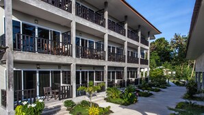 Ein mehrstöckiges Hotel mit Balkonen, großen Fenstern und einem angelegten Innenhof.