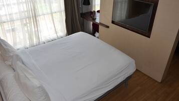Una cama bien tendida con sábanas blancas en una habitación de hotel.