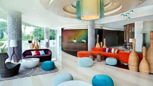 A modern lobby with a reception desk, colorful sofas, and unique vases. - ibis Styles Jakarta Airport (Tangerang)