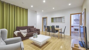 Ein modernes Wohnzimmer mit einer Couch, einem Couchtisch und einem Essbereich mit Stühlen und einem Tisch.