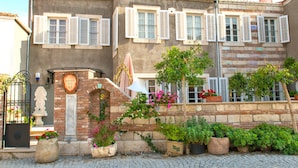 A building with multiple windows, a stone facade, and a brick entrance. - Köstem Hotel (Cesme)