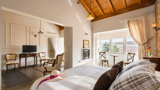 A hotel room with a bed, a desk, a television, and a view of the outdoors. - Köstem Hotel (Cesme)