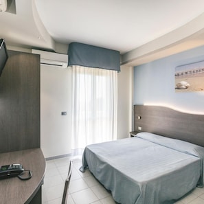 A hotel room with a bed, a desk with a telephone, and a window with curtains. - Hotel Acquario (Vasto)