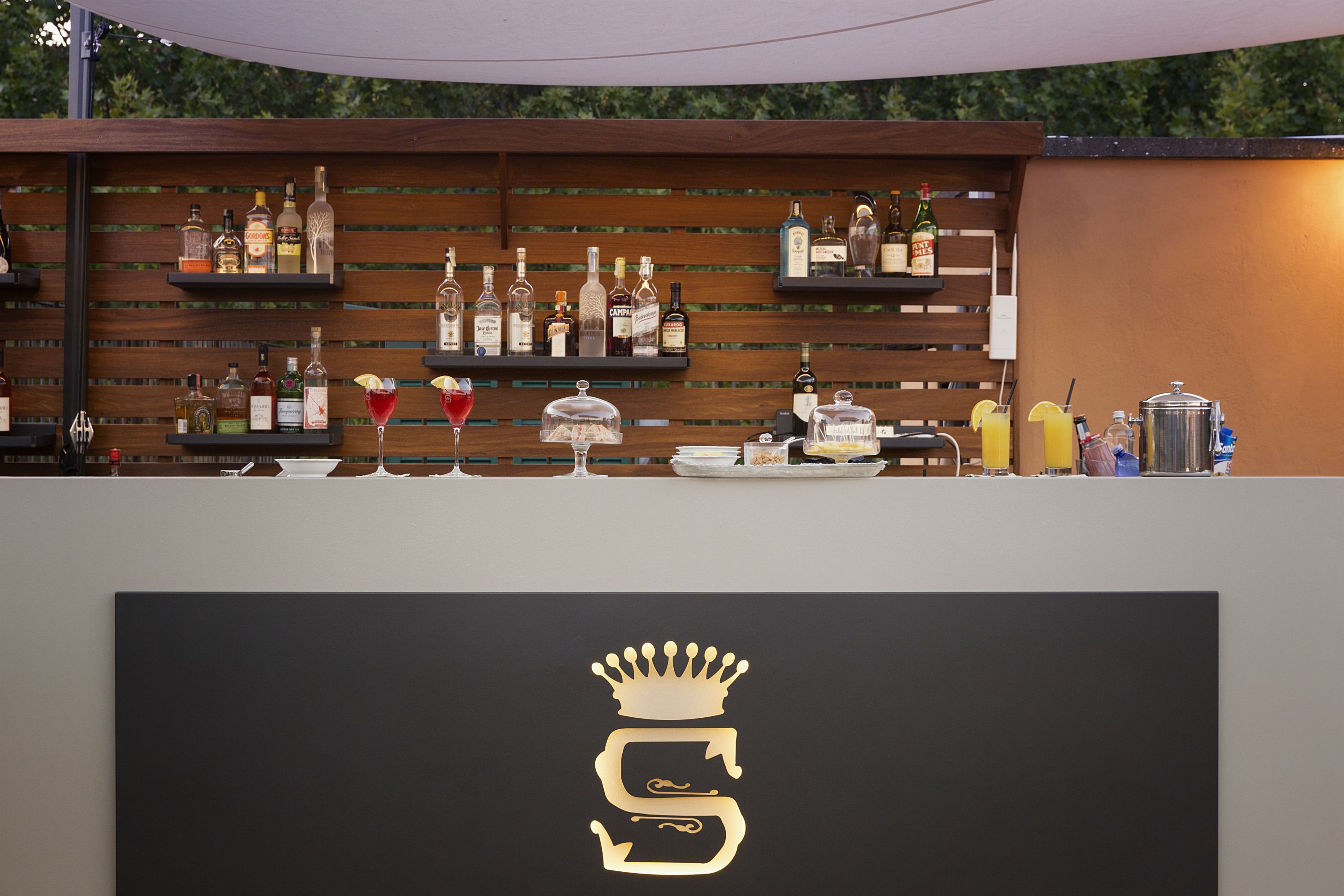 A bar area with shelves of liquor bottles and glasses.