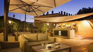 Un espace extérieur aménagé avec un canapé, une table et un bar.