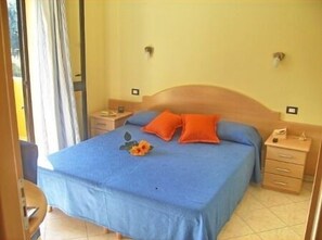 A bedroom with a single bed, two nightstands, and a window with curtains. - Residence Hotel Riviera Calabra (Zambrone)