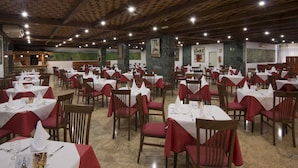 A spacious restaurant with multiple tables and chairs, each set with white tablecloths and red napkins. - Hotel Elegance Palmeras Playa (Puerto de la Cruz)