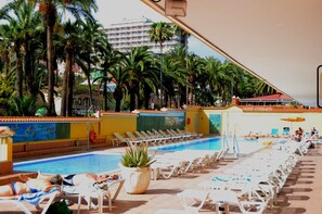 A pool area with sun loungers and palm trees. - Hotel Elegance Palmeras Playa (Puerto de la Cruz)