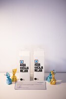 Zwei Milchkartons mit dem Text „AGUA ENCAJA MEJOR“ und zwei Schokoladenbonbons.