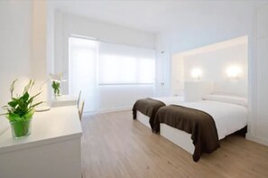 Ein modernes Schlafzimmer mit Bett, Nachttischen und einer Zimmerpflanze.