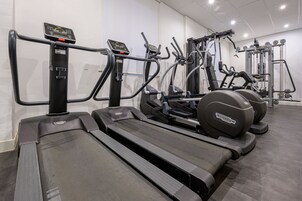 A gym with treadmills, elliptical machines, and weight machines.