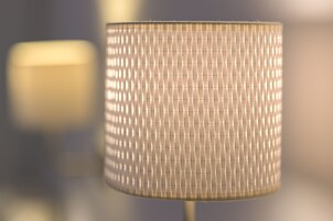 Ein Detailaufnahme einer strukturierten, zylindrischen Lampe mit gerippter Oberfläche.