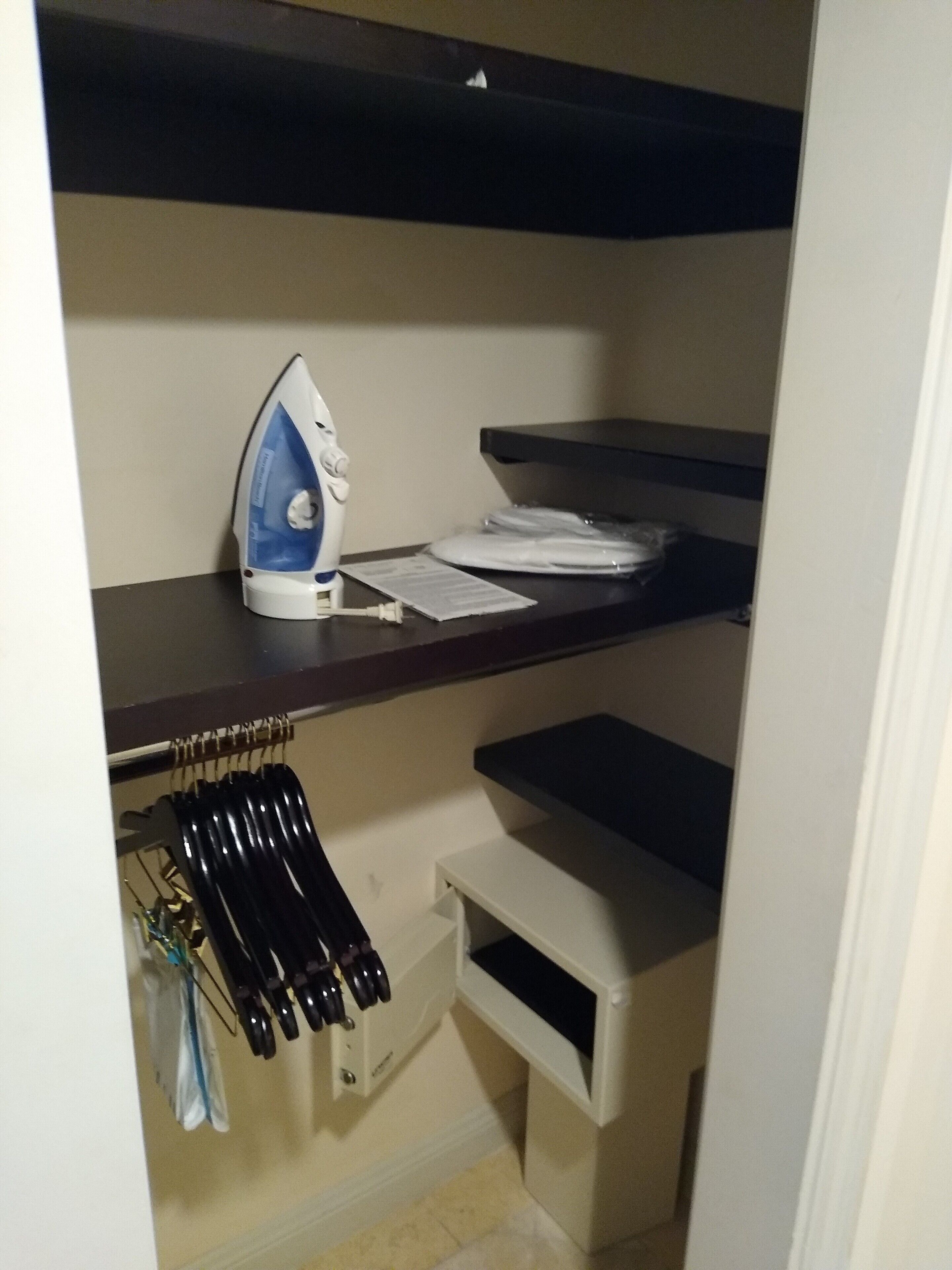 A compact storage unit with shelves, a hanging rack, and a small drawer.