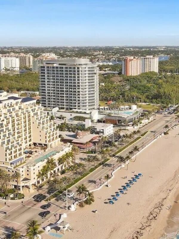 Na praia, areia branca, espreguiçadeiras, toalhas de praia