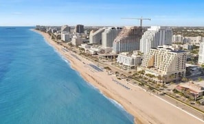 En la playa, arena blanca, sillas reclinables de playa, toallas de playa
