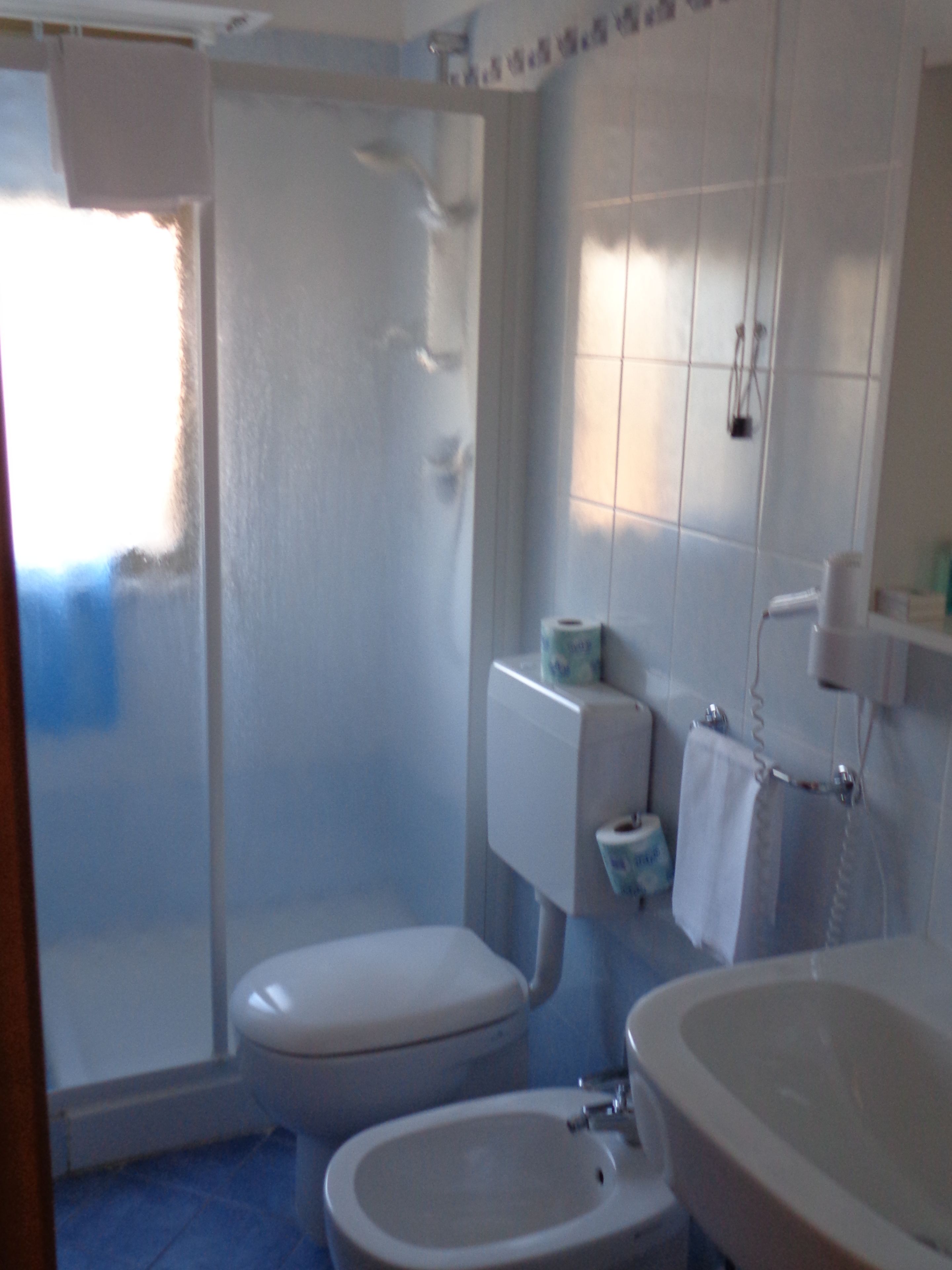 Et badeværelse med toilet, bidet og håndvask.