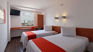 A hotel room with two beds, a TV, a window with a city view, and a desk with a chair. - One Villahermosa Centro (Villahermosa)