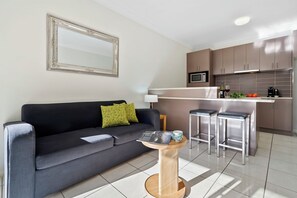 Departamento ejecutivo, 1 habitación | Área de sala de estar | Televisión de 42 pulgadas con canales vía satélite y Netflix 